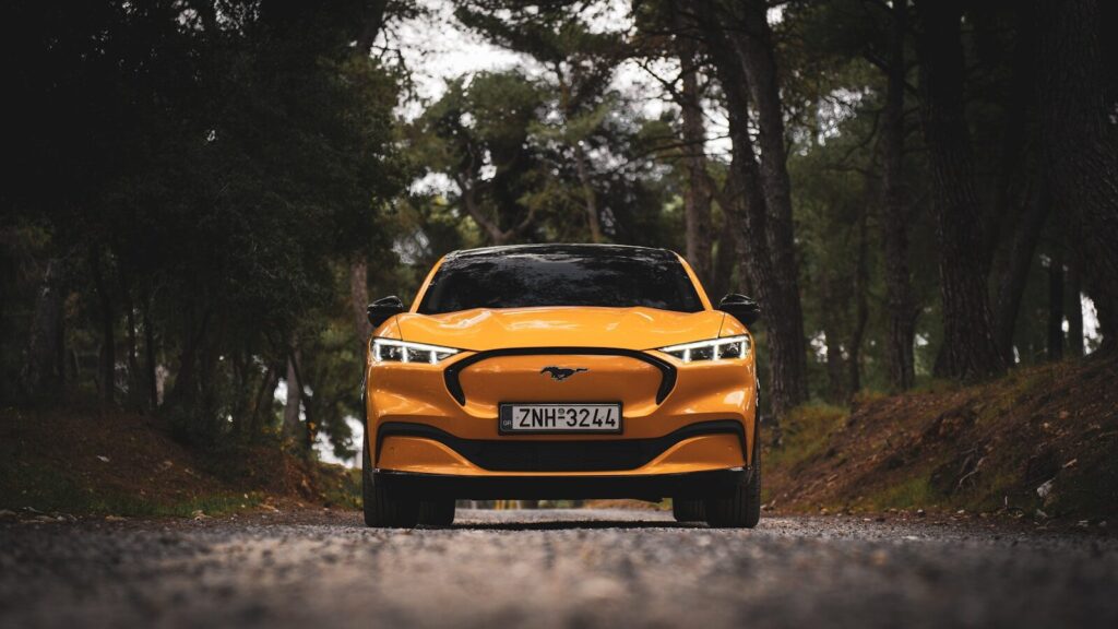 a yellow car is driving down the road